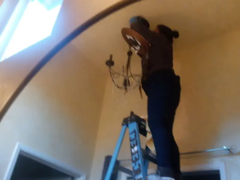 Electrician installing a chandelier in a Upper Grand Lagoon residence